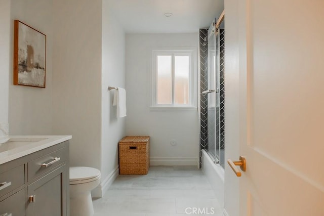 bathroom featuring bathtub / shower combination, toilet, vanity, and baseboards