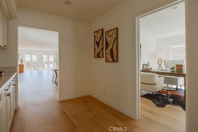 hallway featuring baseboards and light wood finished floors