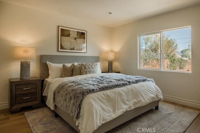 bedroom with wood finished floors and baseboards