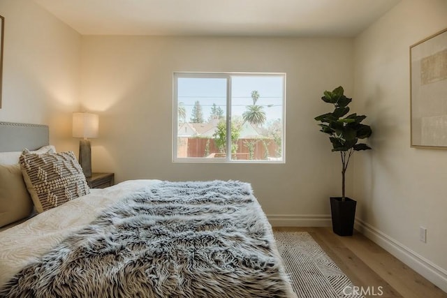 bedroom with light wood-type flooring and baseboards