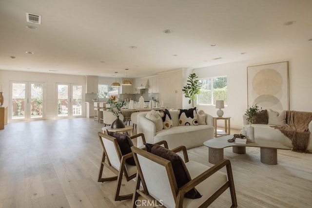 living area featuring light wood finished floors and visible vents