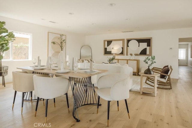 dining space featuring visible vents and light wood-style floors