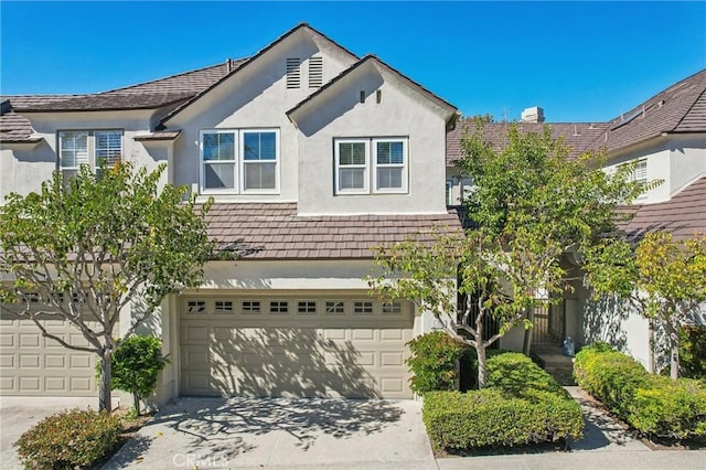 view of front facade with driveway, an attached garage, and stucco siding