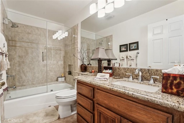 full bathroom with shower / bath combination with glass door, vanity, and toilet