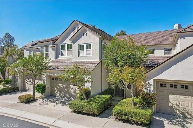 view of front of house with a garage, driveway, and stucco siding