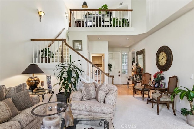 living room with stairway and a high ceiling