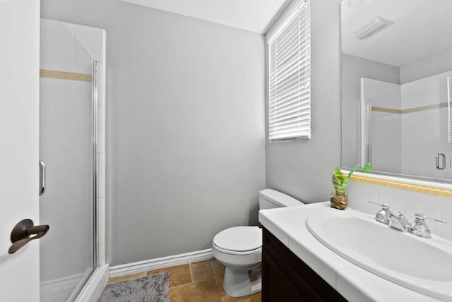 full bath featuring toilet, vanity, baseboards, and a shower stall