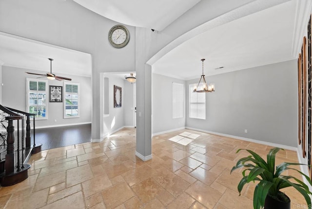 entrance foyer with a healthy amount of sunlight, baseboards, and stone tile flooring