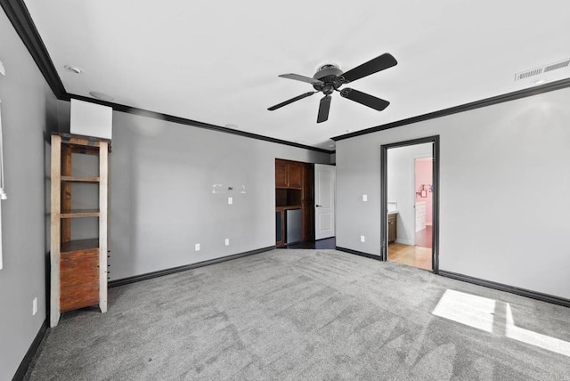 unfurnished bedroom with crown molding, carpet floors, baseboards, and a ceiling fan