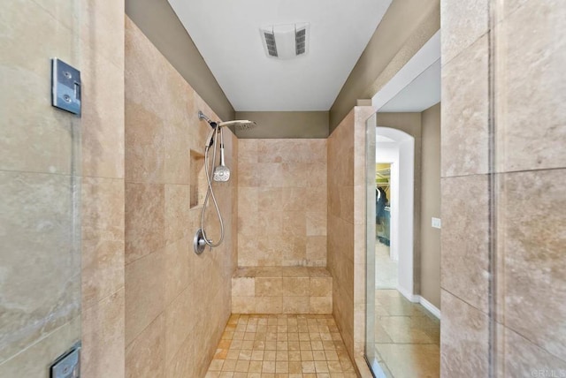 full bath with visible vents and a tile shower
