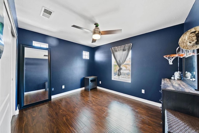 empty room with visible vents, baseboards, wood finished floors, and ceiling fan