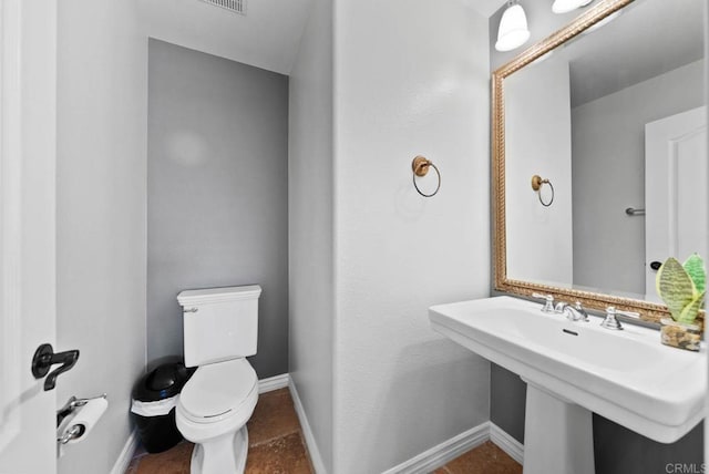 half bath featuring toilet and baseboards