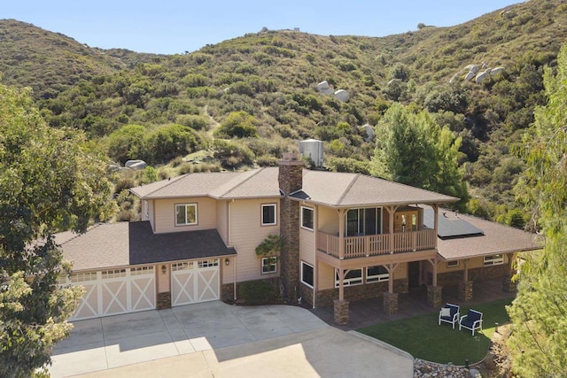 birds eye view of property with a wooded view and a mountain view