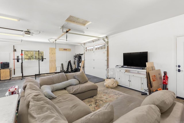 living room featuring a garage, attic access, and concrete flooring