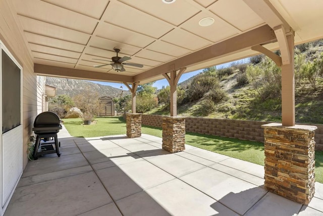 view of patio / terrace with an outdoor structure, ceiling fan, area for grilling, and a mountain view