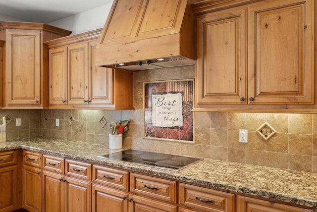 6433 Dehesa Rd, El Cajon, CA 92019 - kitchen with backsplash, brown cabinets, light stone counters, custom range hood, and black electric stovetop
