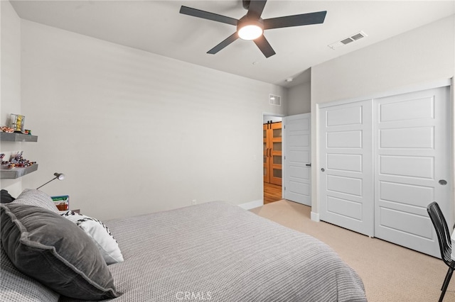 bedroom featuring a closet, light colored carpet, visible vents, ceiling fan, and baseboards