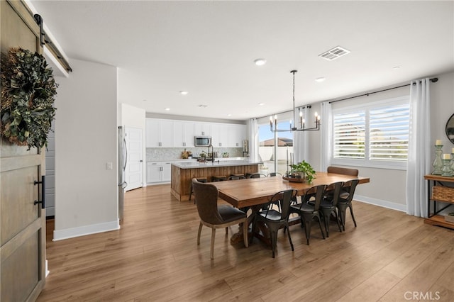 dining room with light wood-style flooring, recessed lighting, visible vents, baseboards, and an inviting chandelier