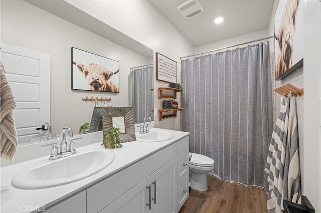 bathroom with visible vents, wood finished floors, a sink, and toilet