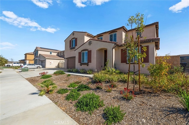 mediterranean / spanish-style house with concrete driveway, an attached garage, and stucco siding