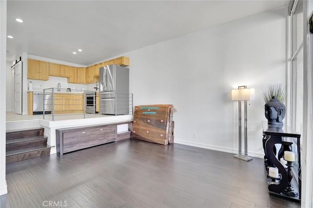 kitchen featuring dark wood-style flooring, recessed lighting, light countertops, light brown cabinetry, and appliances with stainless steel finishes