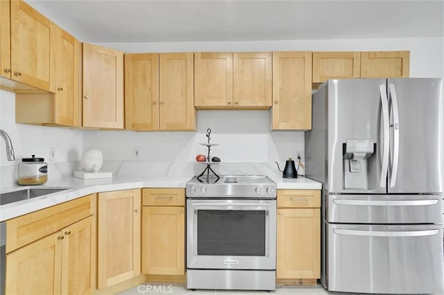 kitchen featuring light brown cabinets, appliances with stainless steel finishes, light countertops, and a sink