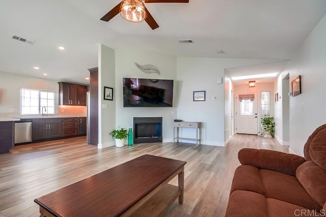 living area featuring light wood-type flooring, visible vents, a fireplace, and recessed lighting