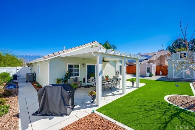 rear view of property featuring central AC unit, a gate, a patio area, a shed, and an outdoor structure