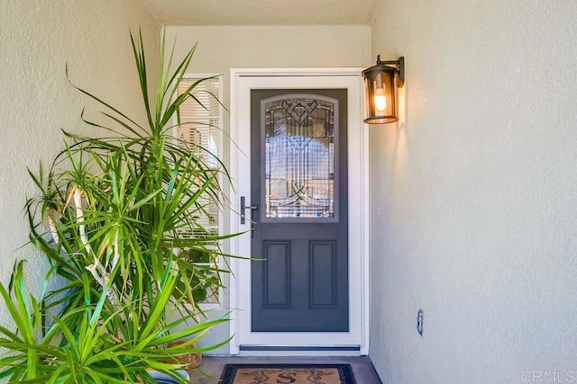 entrance to property featuring stucco siding