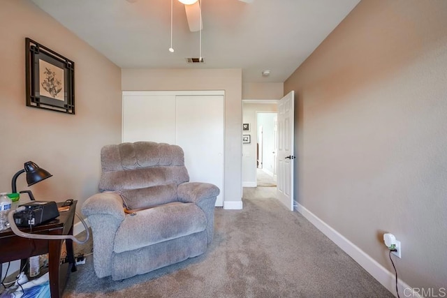 sitting room featuring a ceiling fan, carpet flooring, visible vents, and baseboards