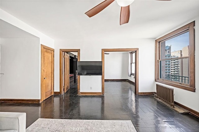 spare room featuring radiator heating unit, baseboards, and a ceiling fan