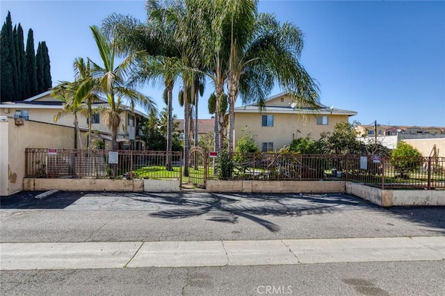 view of front facade featuring a fenced front yard, a gate, and stucco siding