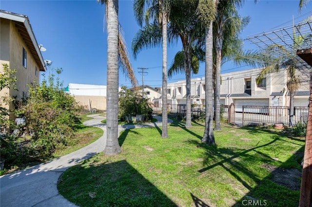 view of home's community featuring a residential view, fence, and a lawn