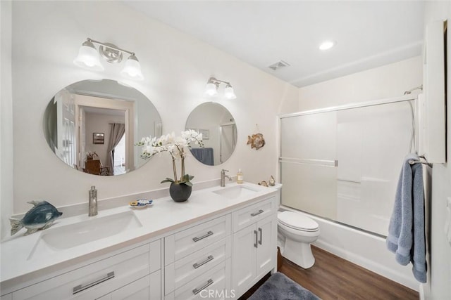 full bathroom with toilet, visible vents, a sink, and wood finished floors