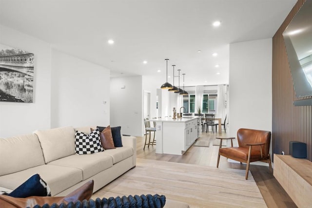 living area with recessed lighting and light wood-style floors