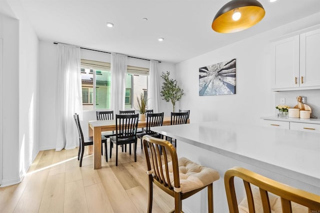 dining space with light wood finished floors, baseboards, and recessed lighting