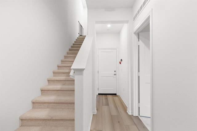 stairs featuring visible vents and wood finished floors