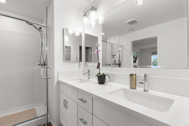 bathroom featuring double vanity, a sink, visible vents, and a shower stall