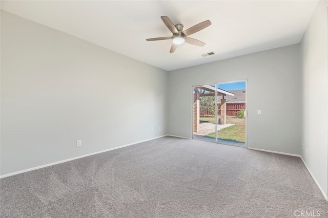 empty room featuring carpet floors, baseboards, visible vents, and a ceiling fan