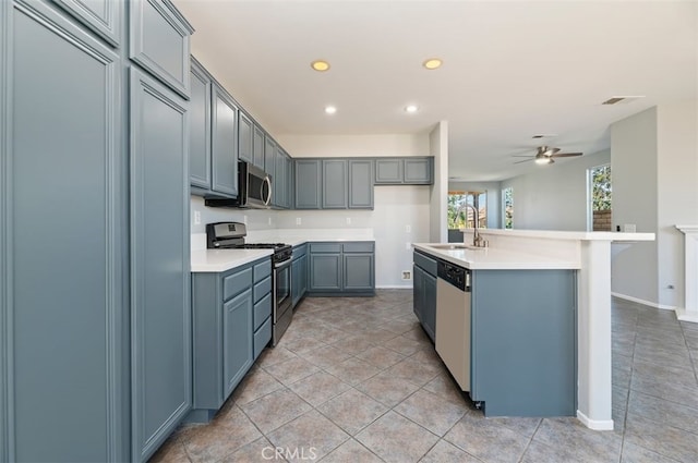 kitchen featuring light countertops, visible vents, appliances with stainless steel finishes, a kitchen island with sink, and a sink