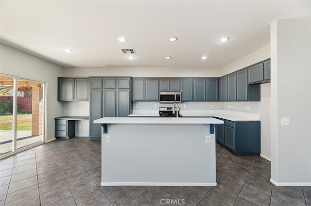 kitchen with a center island with sink, visible vents, appliances with stainless steel finishes, light countertops, and recessed lighting