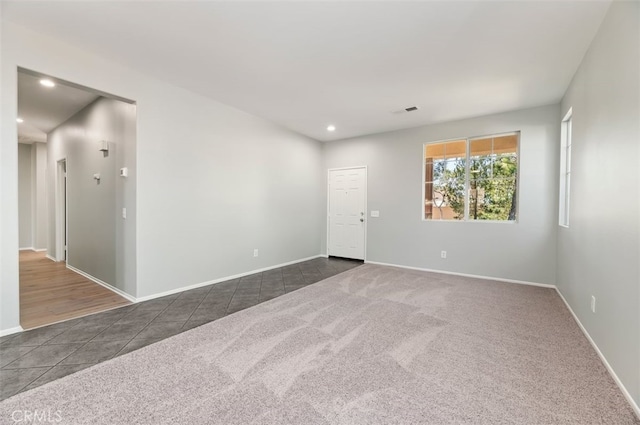 unfurnished room with recessed lighting, baseboards, dark colored carpet, and dark tile patterned flooring