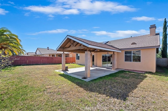 back of house featuring a yard, stucco siding, fence, and a patio