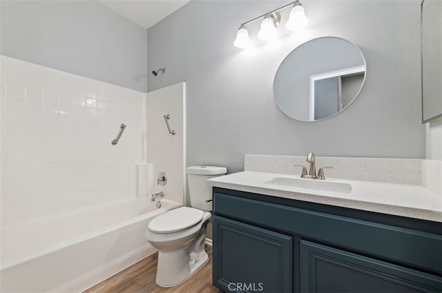 bathroom featuring vanity, bathing tub / shower combination, toilet, and wood finished floors