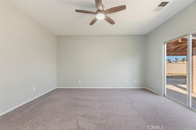 carpeted spare room featuring a ceiling fan, visible vents, and baseboards