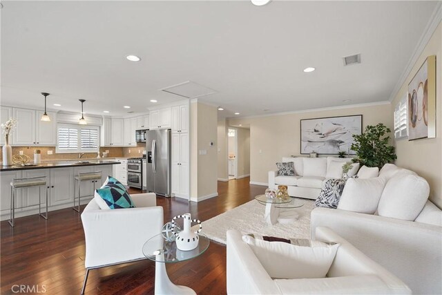 living area featuring visible vents, recessed lighting, dark wood-type flooring, and ornamental molding