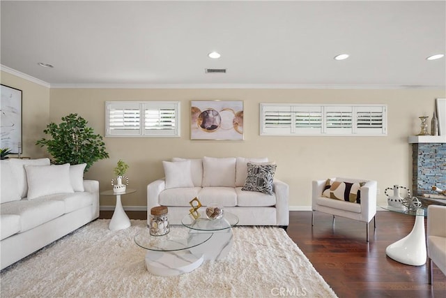 living room featuring wood finished floors, visible vents, baseboards, recessed lighting, and ornamental molding