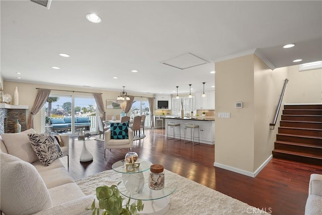 living room featuring stairway, baseboards, recessed lighting, ornamental molding, and dark wood-type flooring