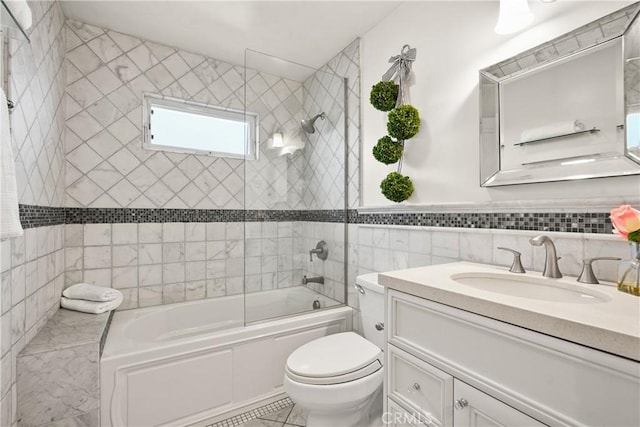 bathroom featuring toilet, tile walls, wainscoting, tub / shower combination, and vanity