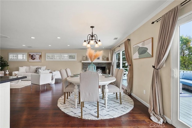 dining room with baseboards, dark wood finished floors, ornamental molding, recessed lighting, and an inviting chandelier